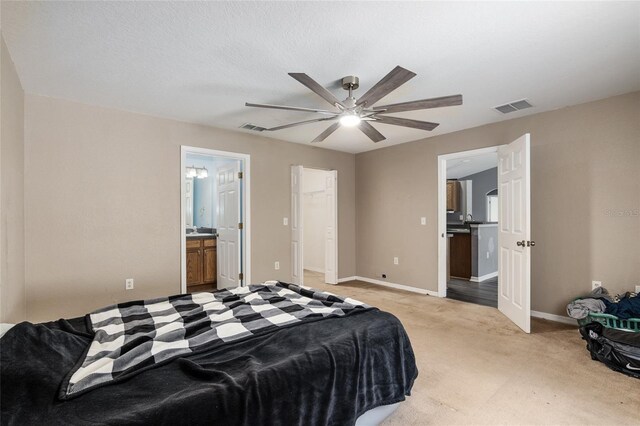 carpeted bedroom featuring a closet, ensuite bathroom, and ceiling fan