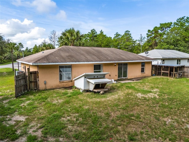 rear view of property featuring a lawn