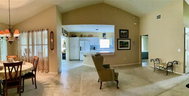 carpeted living room with high vaulted ceiling and an inviting chandelier