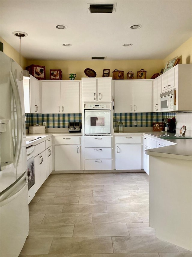 kitchen with white appliances, white cabinets, and tasteful backsplash