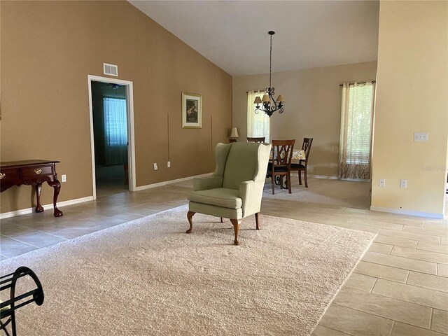 sitting room featuring light colored carpet, an inviting chandelier, and high vaulted ceiling