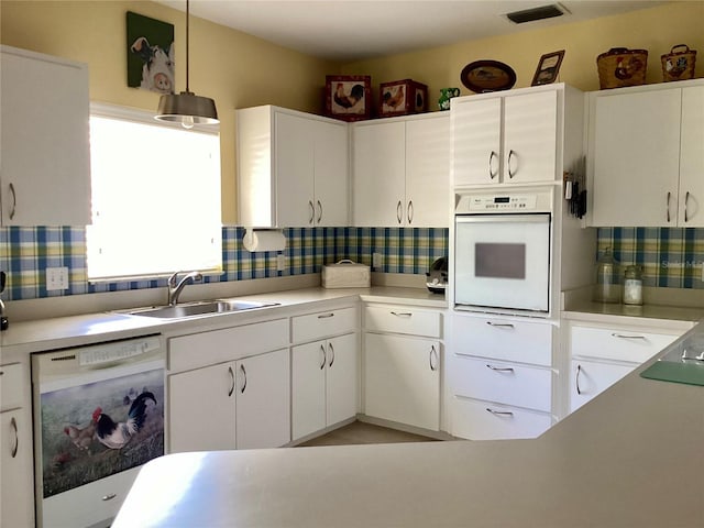 kitchen featuring white appliances, tasteful backsplash, white cabinetry, and sink