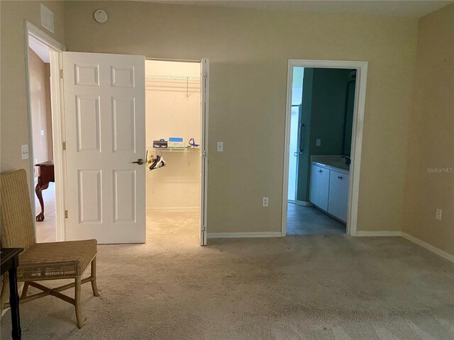 bedroom featuring a closet, a spacious closet, and light carpet