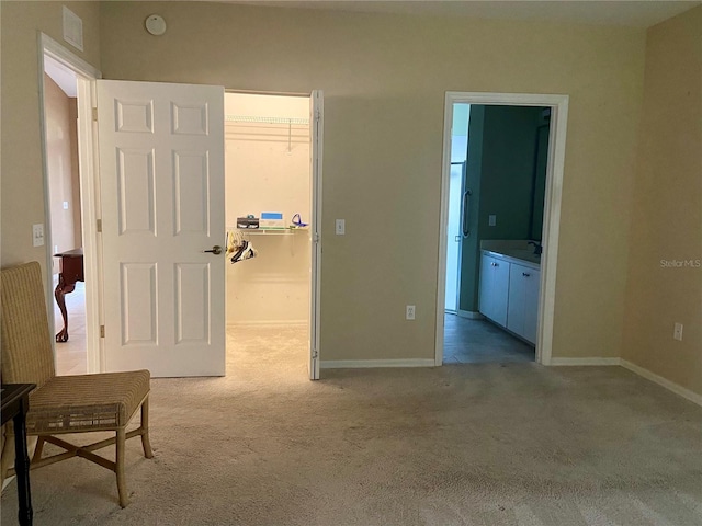 9288 SW 192nd Court Rd, Dunnellon, FL 34432 - bedroom with a walk in closet, light carpet, baseboards, and ensuite bathroom