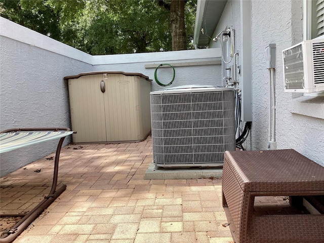 view of patio with a storage shed and cooling unit