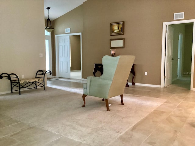 living area with high vaulted ceiling and light tile patterned flooring