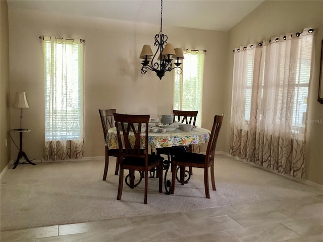 carpeted dining area featuring lofted ceiling and a notable chandelier