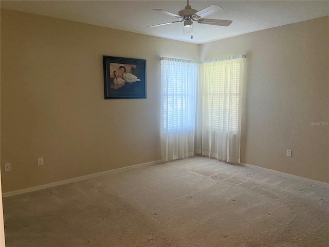 carpeted spare room with ceiling fan