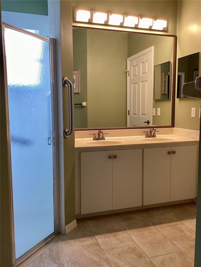 bathroom featuring tile patterned floors, a shower with door, and vanity