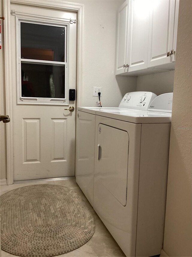 laundry area with washing machine and clothes dryer and cabinets