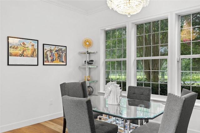 dining room featuring hardwood / wood-style flooring, ornamental molding, and a notable chandelier