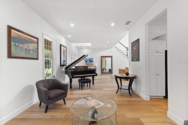 sitting room featuring a skylight and light wood-type flooring