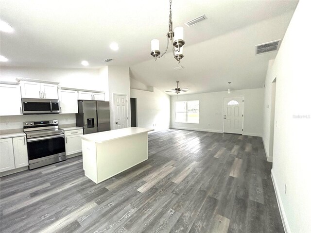 kitchen with a kitchen island, pendant lighting, appliances with stainless steel finishes, white cabinets, and ceiling fan with notable chandelier