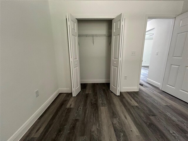 unfurnished bedroom featuring a closet and dark hardwood / wood-style flooring