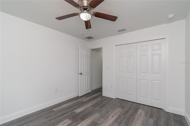 unfurnished bedroom with dark wood-type flooring, ceiling fan, and a closet