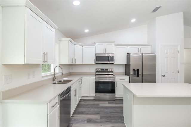 kitchen featuring sink, white cabinetry, stainless steel appliances, and vaulted ceiling