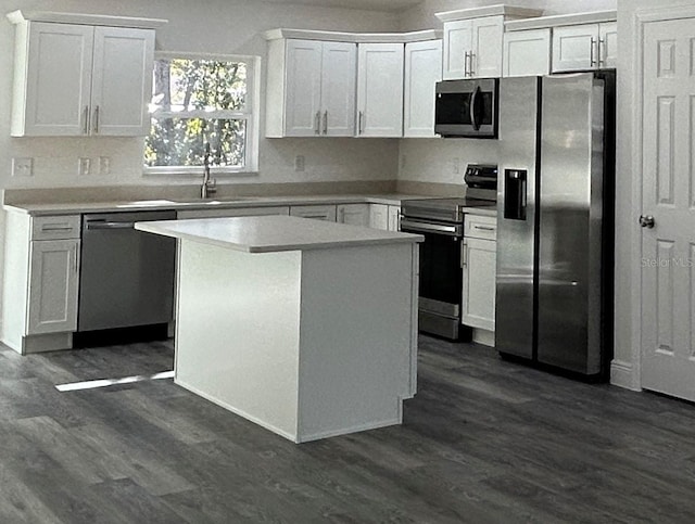 kitchen featuring dark hardwood / wood-style floors, a kitchen island, sink, appliances with stainless steel finishes, and white cabinets