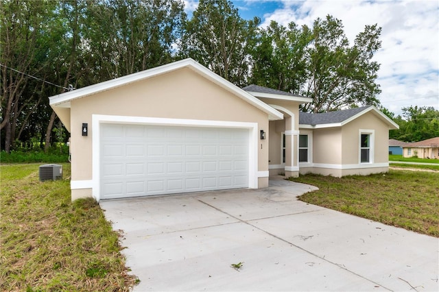 ranch-style home with a front yard, central AC, and a garage