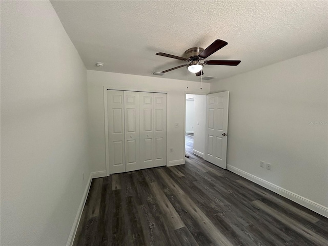 unfurnished bedroom featuring ceiling fan, dark wood-type flooring, a textured ceiling, and a closet