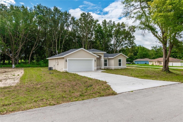 ranch-style house featuring a front lawn, central AC unit, and a garage