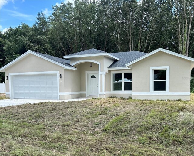 single story home with an attached garage, stucco siding, and roof with shingles