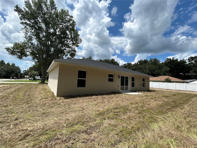 rear view of property featuring stucco siding