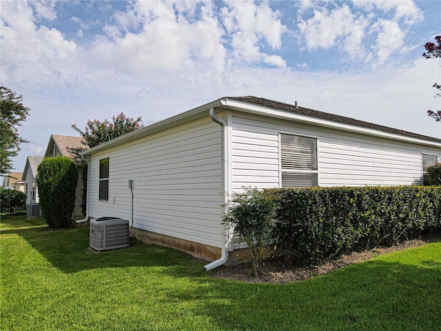 view of property exterior with cooling unit and a yard