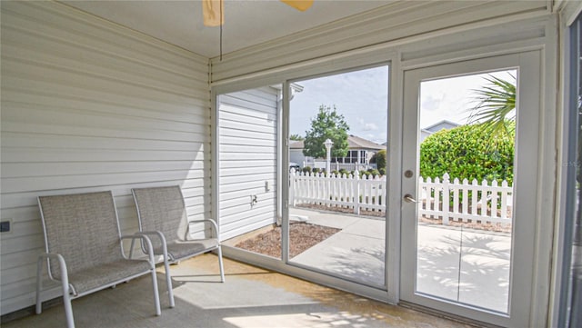 unfurnished sunroom with ceiling fan