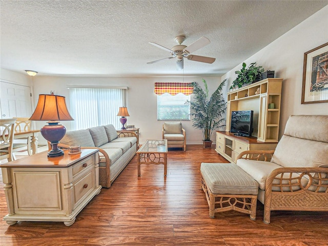 living room with a textured ceiling, hardwood / wood-style floors, and ceiling fan