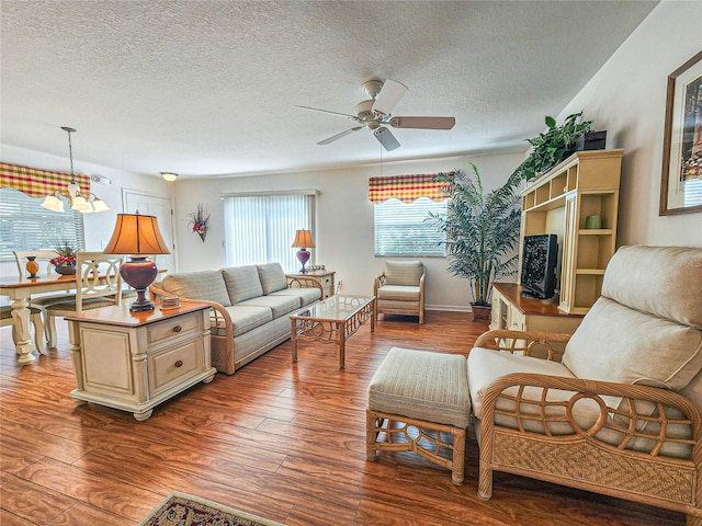 living room featuring a textured ceiling, ceiling fan with notable chandelier, and hardwood / wood-style floors