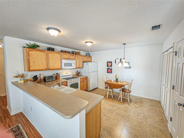 kitchen with light hardwood / wood-style flooring, white appliances, a chandelier, kitchen peninsula, and sink