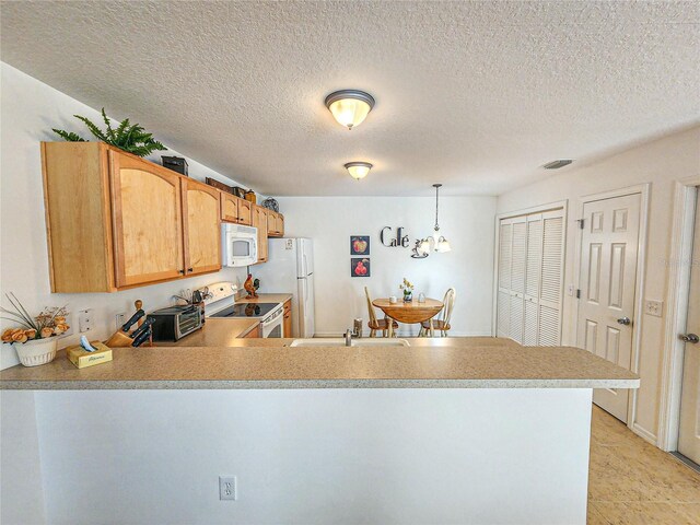 kitchen featuring white appliances, light tile patterned floors, a textured ceiling, kitchen peninsula, and decorative light fixtures