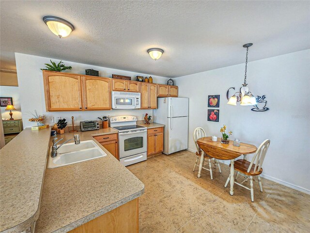 kitchen with a notable chandelier, white appliances, light tile patterned floors, hanging light fixtures, and sink