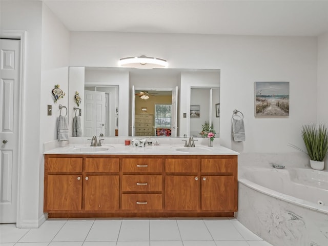 bathroom with a washtub, vanity, ceiling fan, and tile patterned floors