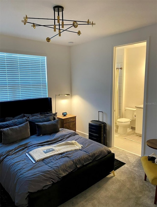 tiled bedroom with ensuite bath and a chandelier