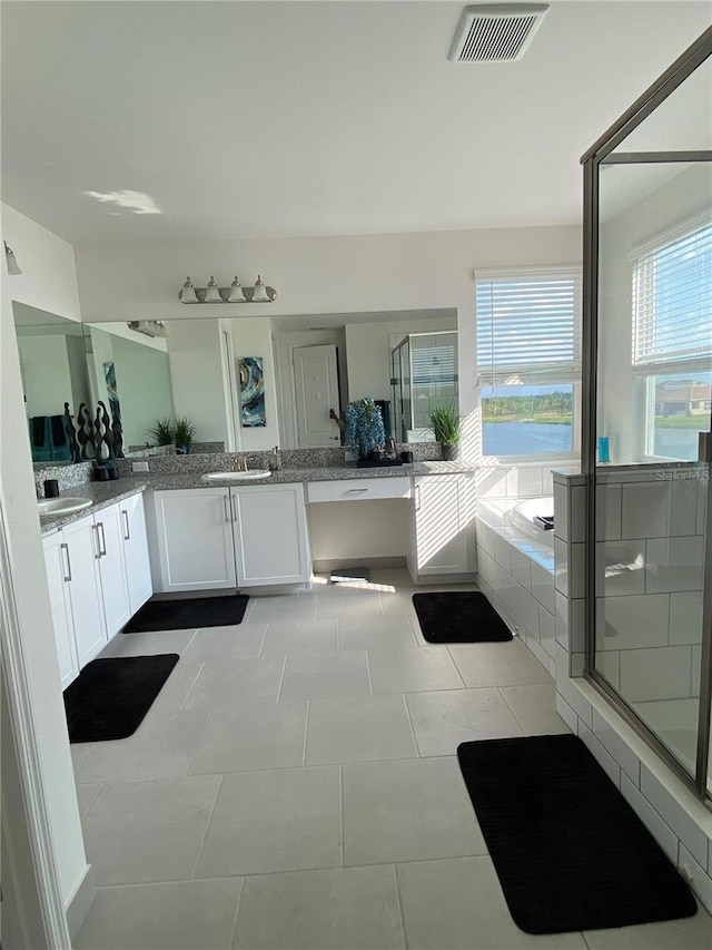 bathroom featuring plus walk in shower, vanity, and tile patterned floors