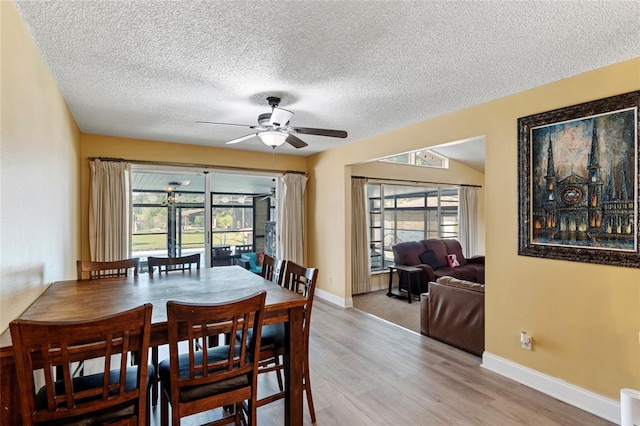 dining space with a textured ceiling, ceiling fan, and light wood-type flooring