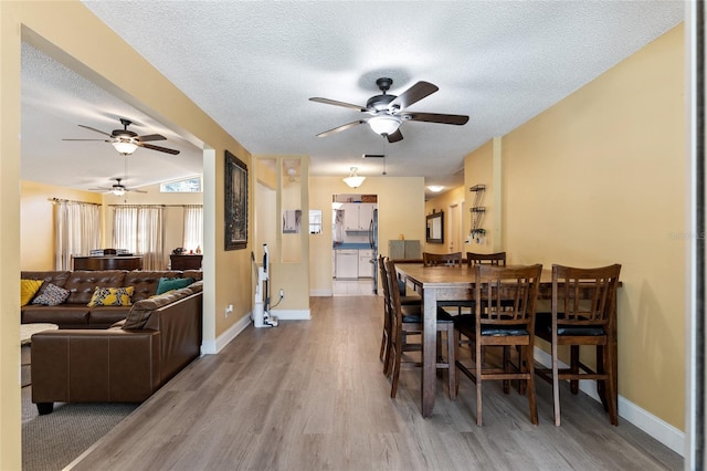 dining room with hardwood / wood-style flooring, a textured ceiling, and ceiling fan