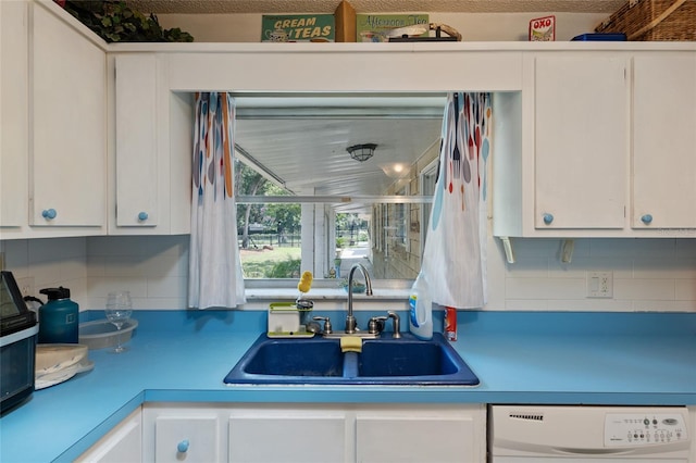 kitchen with sink, dishwasher, white cabinets, and tasteful backsplash