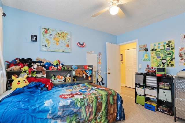 carpeted bedroom featuring a textured ceiling, a closet, and ceiling fan