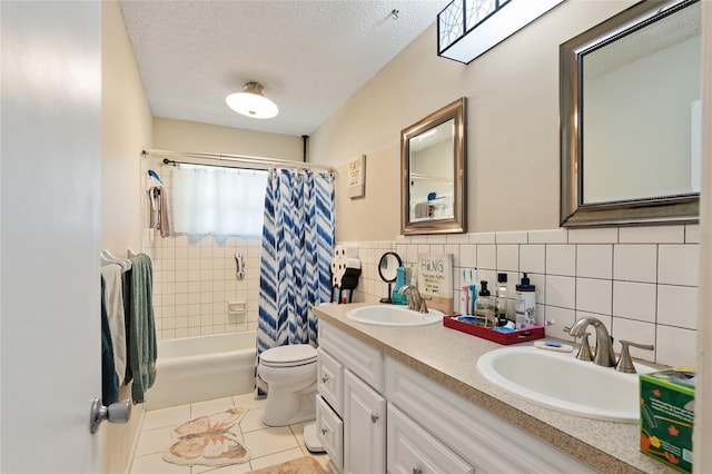 full bathroom featuring tasteful backsplash, tile patterned floors, dual bowl vanity, a textured ceiling, and shower / tub combo with curtain