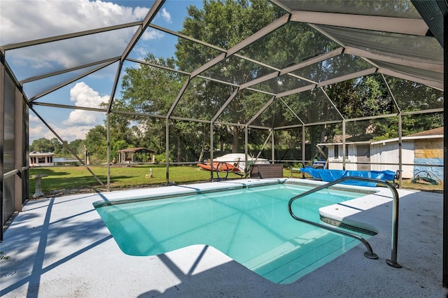 view of pool featuring glass enclosure, a yard, and a patio