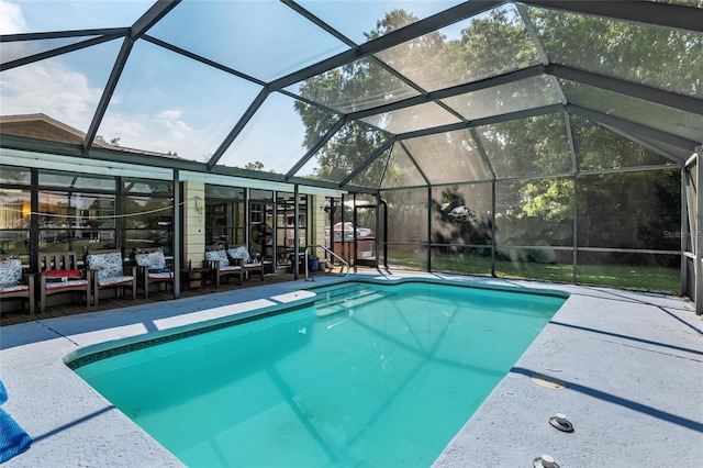 view of pool with glass enclosure and a patio