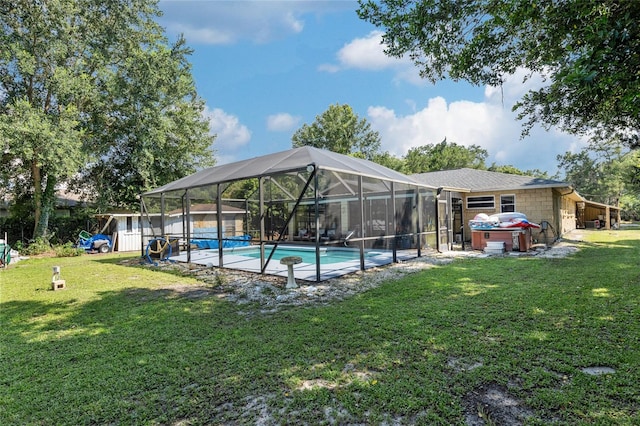 view of pool with glass enclosure, a patio area, and a lawn