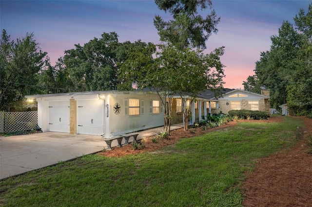 view of front of property with a garage and a yard