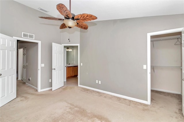 unfurnished bedroom featuring a closet, carpet, ceiling fan, and vaulted ceiling