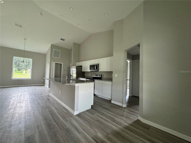 kitchen featuring hardwood / wood-style floors, stainless steel appliances, white cabinetry, and a kitchen island with sink