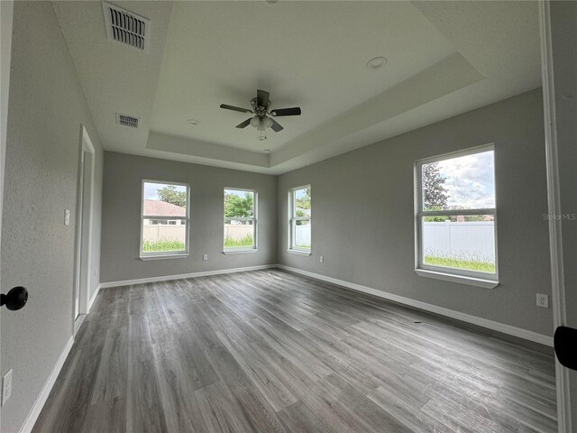 spare room featuring ceiling fan, hardwood / wood-style flooring, and a tray ceiling