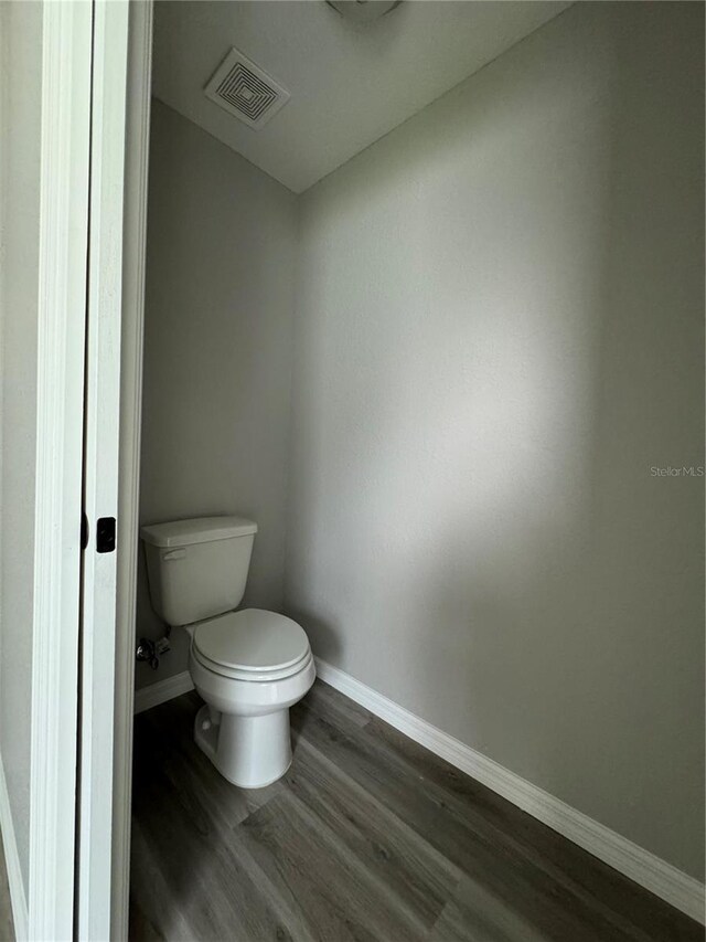 bathroom with toilet and hardwood / wood-style floors