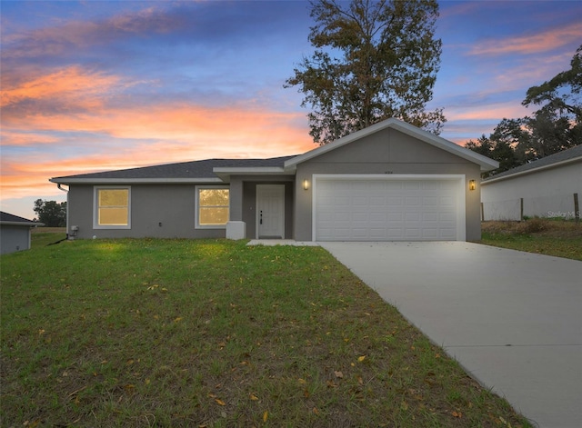 single story home with a lawn and a garage